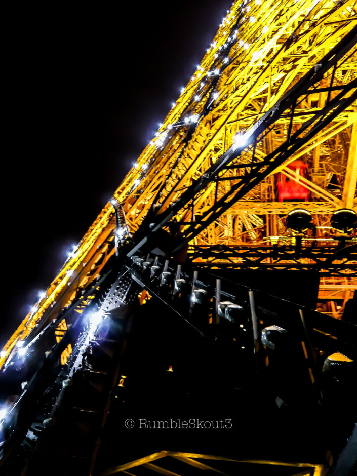 A small red lift/elevator flies by during an Eiffel Tower display of sparkling and twinkling lights on the Champs de Mars, 7th arrondissement de Paris. Petit Elevador Rouge