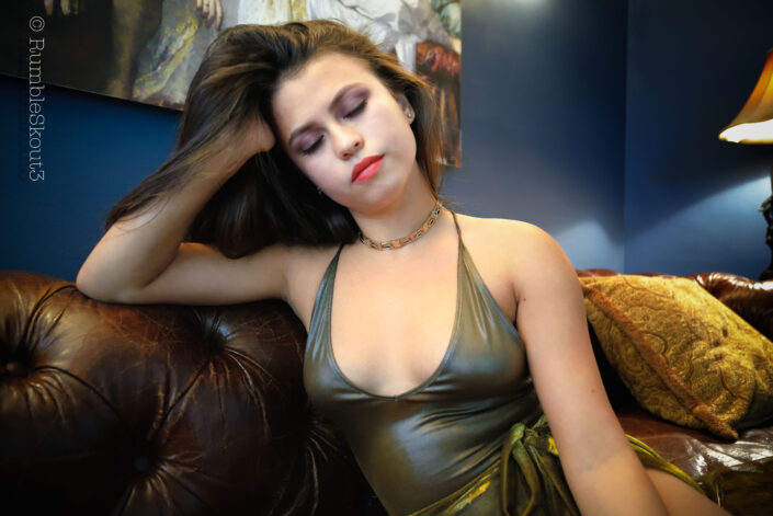 An American woman portrait of an Easy Listening, Playing Around on Leather VII, session, in a bodysuit sheer dress on a leather chesterfield sofa in West Hollywood.